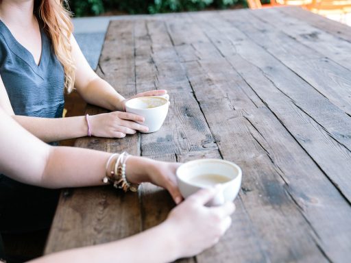 Twee mensen in een diep gesprek aan een tafel met koffie