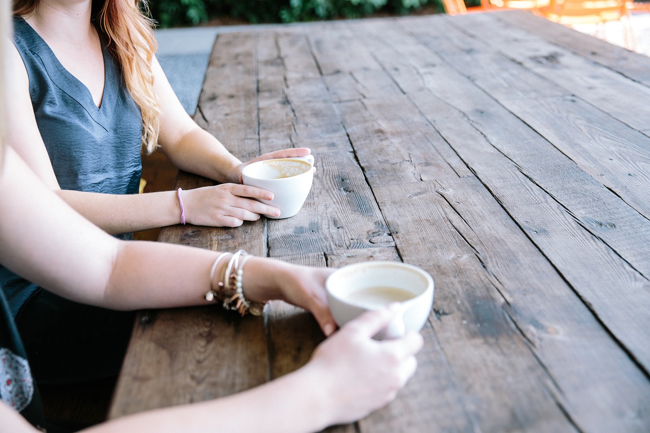 Twee mensen in een diep gesprek aan een tafel met koffie