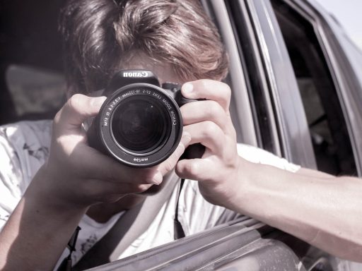 Persoon die door de zoeker van een camera kijkt tijdens een meditatief fotografeermoment buiten