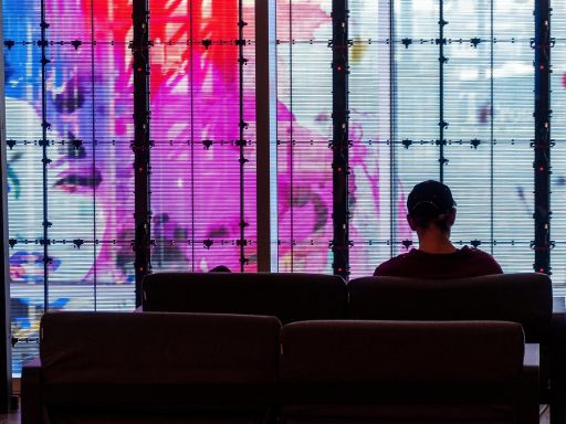 Persoon zit alleen bij een raam en kijkt peinzend naar buiten