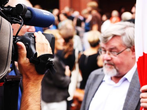 Persoon die thuis op de bank een emotioneel interview bekijkt op televisie