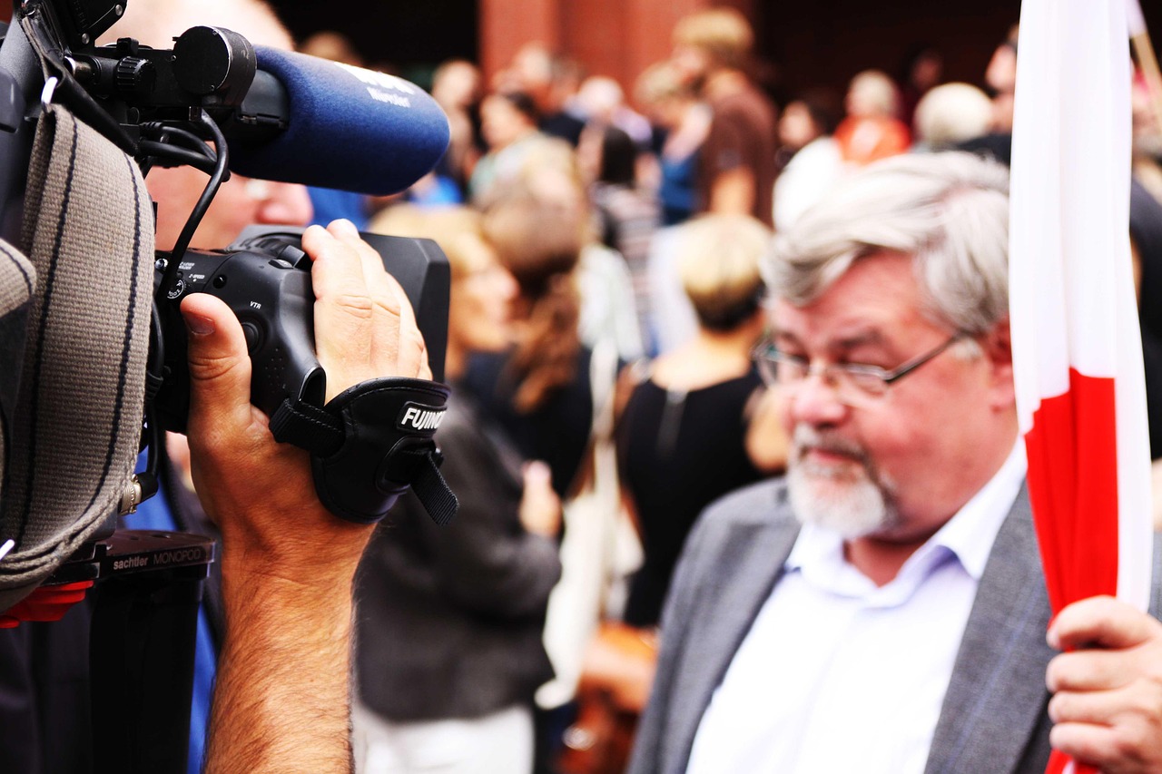 Persoon die thuis op de bank een emotioneel interview bekijkt op televisie