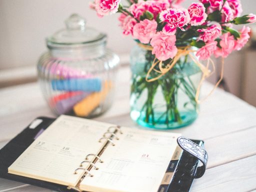 Opengeslagen boeken op een houten bureau met een notitieboekje ernaast