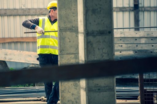 Een stratenmaker die met precisie tegels legt op een terras, zichtbaar trots op het vakmanschap