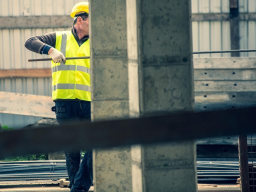 Een stratenmaker die met precisie tegels legt op een terras, zichtbaar trots op het vakmanschap