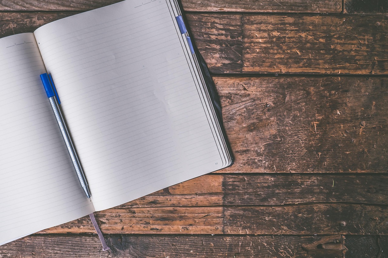 Persoon die persoonlijke doelen opschrijft in een notitieboek aan een bureau