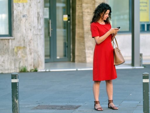 Vrouw kijkt bezorgd naar haar smartphone terwijl ze haar bankrekening bekijkt