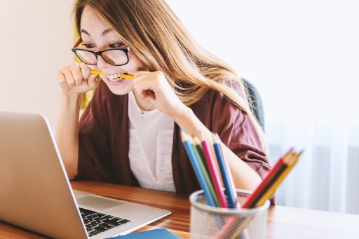 Uitgeputte persoon aan een bureau op kantoor, hoofd in de handen