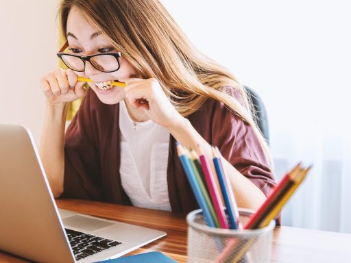 Uitgeputte persoon aan een bureau op kantoor, hoofd in de handen