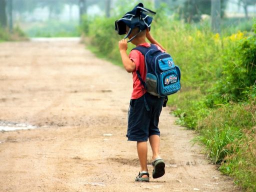 Een moeder staat bij de schoolpoort en zwaait haar kind na op een rustige ochtend