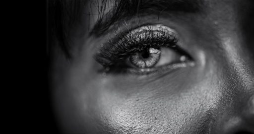 Vrouw die zichzelf bekijkt in een badkamerspiegel, in gedachten verzonken